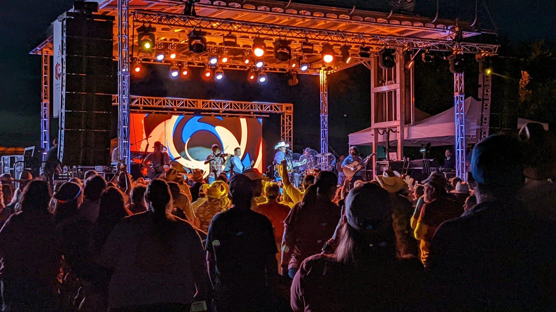 A packed nighttime crowd in front of the lit CRMF stage